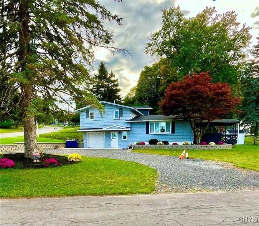 view of front of property with a carport, a front yard, and a garage