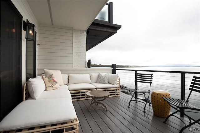 balcony with an outdoor living space and a water view