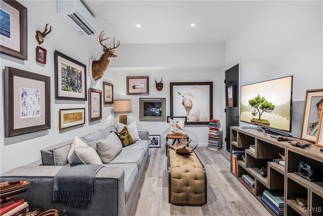 living room featuring light hardwood / wood-style floors and a wall unit AC