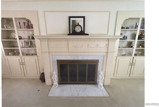 interior details featuring a fireplace and carpet