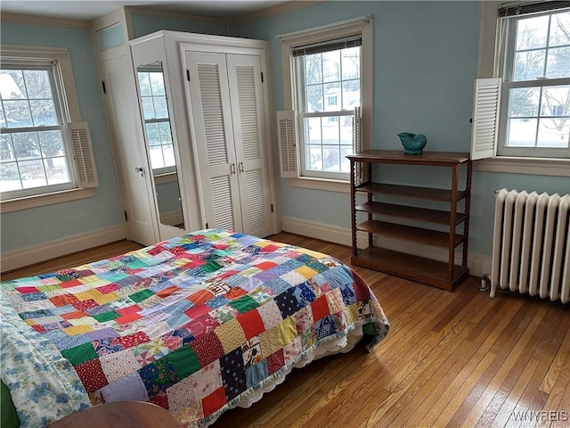 bedroom featuring ornamental molding, hardwood / wood-style floors, and radiator heating unit