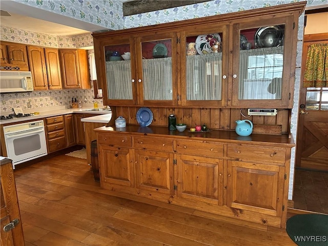 kitchen featuring sink, white appliances, and dark wood-type flooring