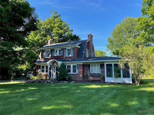 colonial house with a sunroom and a front lawn