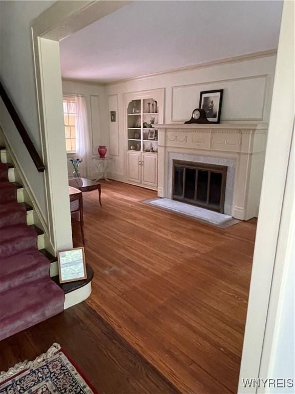 2721 Bowen Rd, Elma, NY 14059 - living area featuring stairway, wood finished floors, a fireplace with flush hearth, and built in shelves