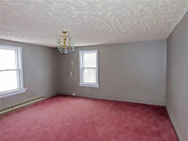 carpeted spare room with a textured ceiling, a baseboard radiator, and a chandelier