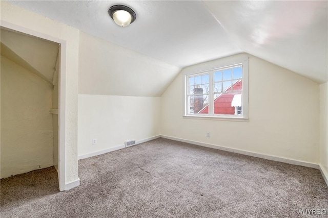 bonus room featuring lofted ceiling and carpet flooring