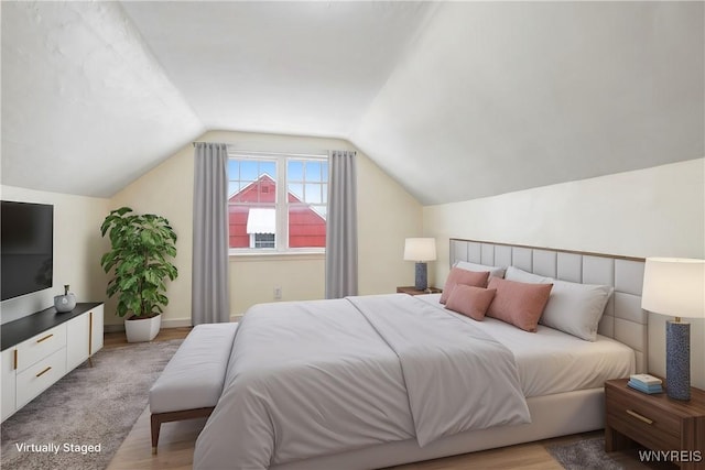 bedroom with light hardwood / wood-style flooring and lofted ceiling