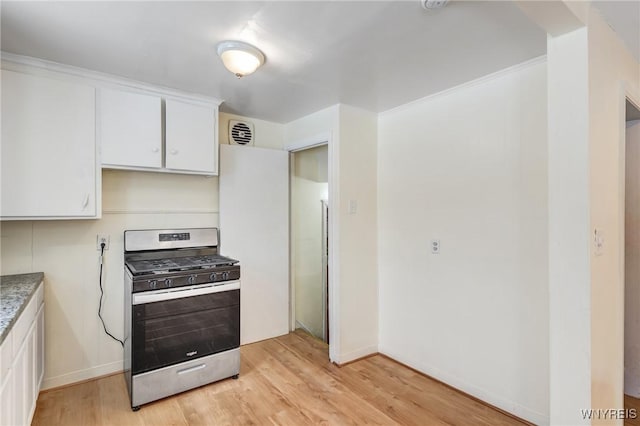 kitchen with gas stove, white cabinetry, and light wood-type flooring