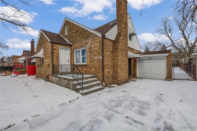 snow covered property with a garage