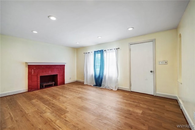 unfurnished living room featuring a fireplace and hardwood / wood-style floors