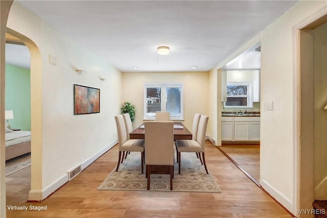 dining area featuring sink and light wood-type flooring