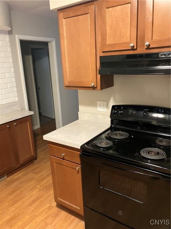 kitchen featuring light hardwood / wood-style flooring and black electric range oven