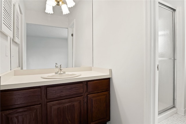 bathroom featuring a shower with door and vanity