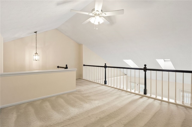 additional living space with ceiling fan, lofted ceiling with skylight, and light carpet