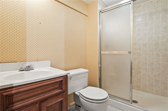 bathroom featuring toilet, a shower with door, and vanity