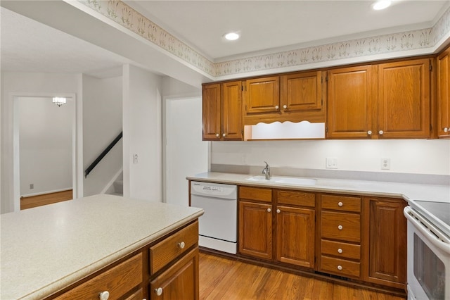 kitchen featuring white appliances, light hardwood / wood-style floors, and sink