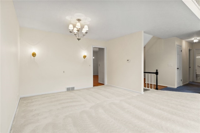 unfurnished room featuring a notable chandelier and light colored carpet