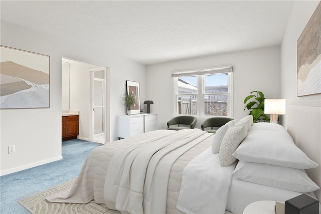 carpeted bedroom with ensuite bathroom and a textured ceiling