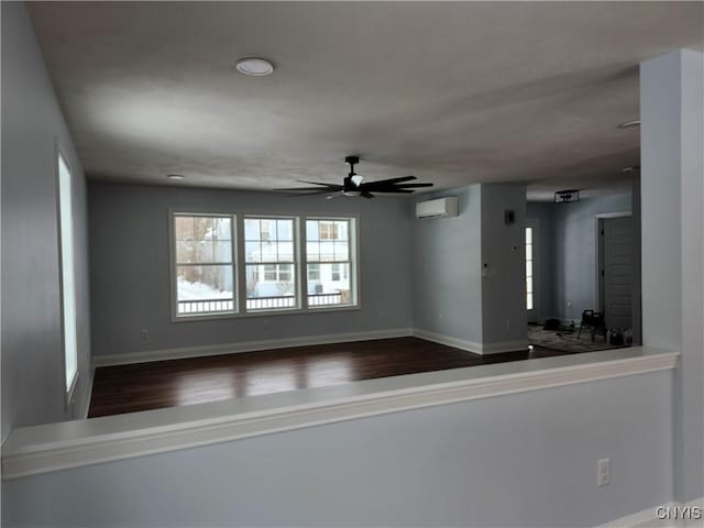 spare room with an AC wall unit and ceiling fan