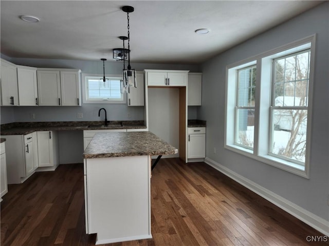 kitchen featuring a center island, pendant lighting, dark hardwood / wood-style floors, white cabinets, and sink