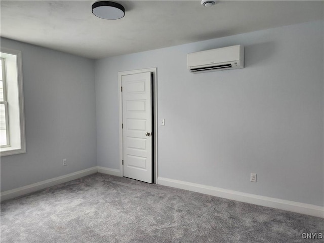 carpeted spare room featuring a wall mounted AC