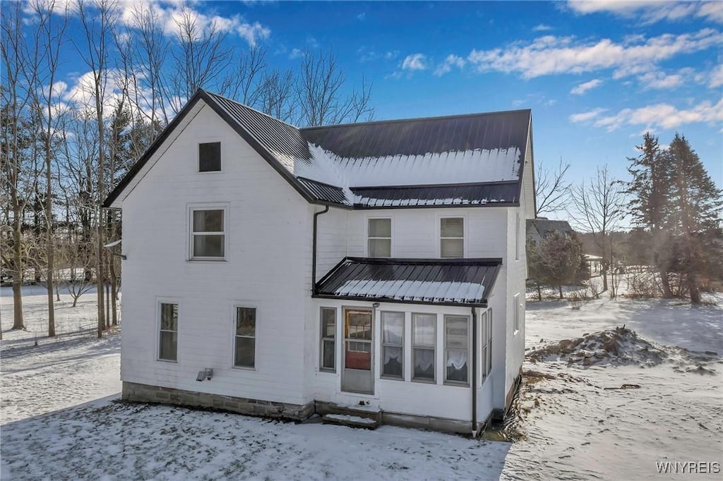 view of snow covered back of property