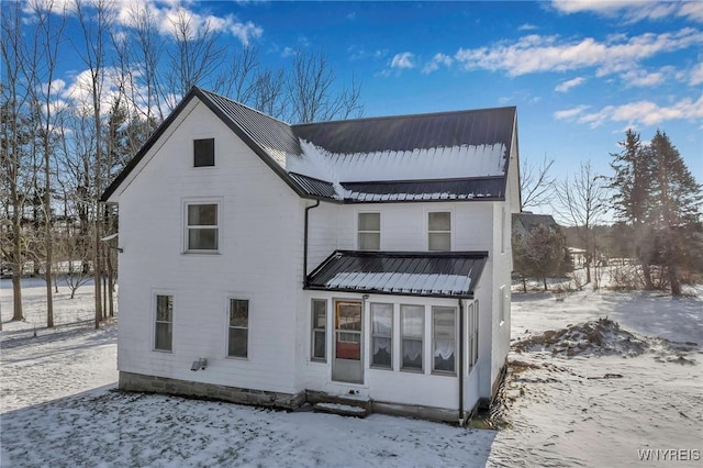 view of snow covered back of property