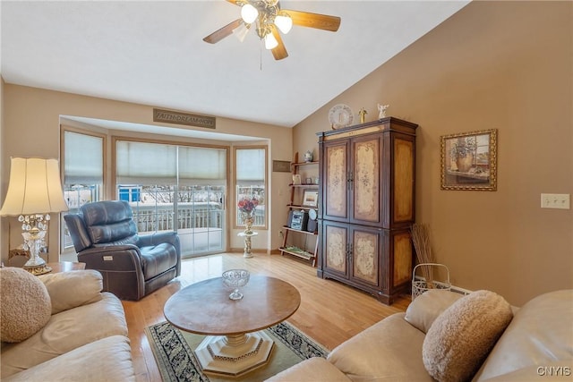 living room featuring ceiling fan, light hardwood / wood-style flooring, and lofted ceiling