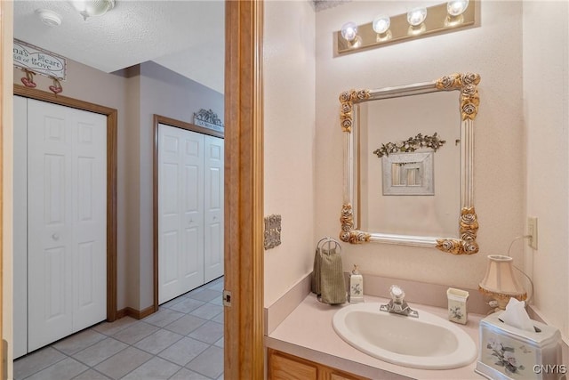 bathroom featuring a textured ceiling, vanity, and tile patterned flooring