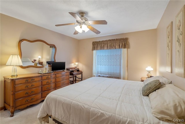 carpeted bedroom featuring a textured ceiling and ceiling fan