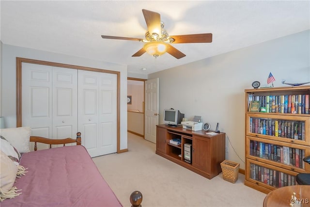 bedroom featuring ceiling fan, a closet, and light carpet