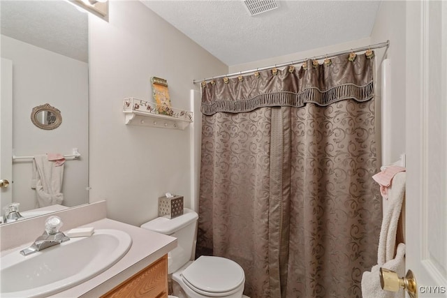 bathroom featuring a textured ceiling, toilet, a shower with curtain, and vanity