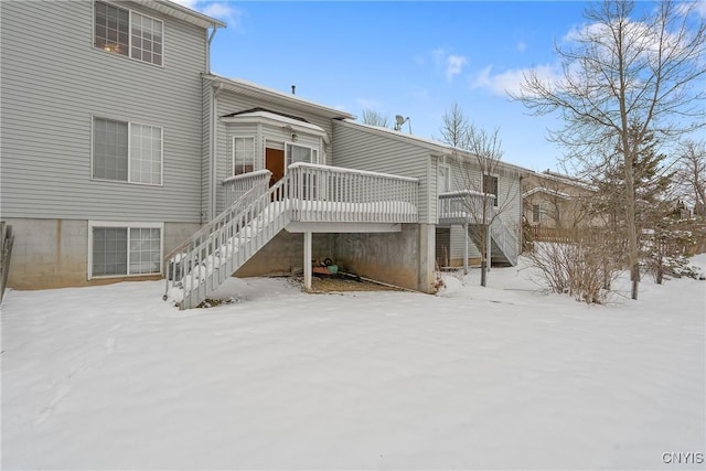 snow covered house featuring a deck