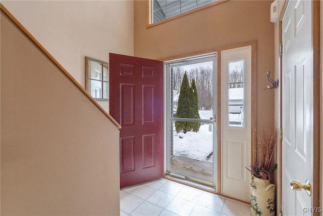 foyer with a high ceiling and light tile patterned floors