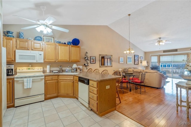 kitchen featuring pendant lighting, kitchen peninsula, light tile patterned flooring, sink, and white appliances