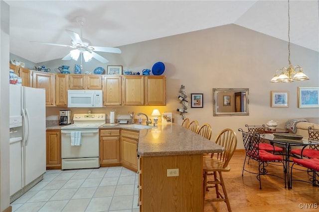 kitchen with white appliances, sink, a kitchen breakfast bar, kitchen peninsula, and vaulted ceiling