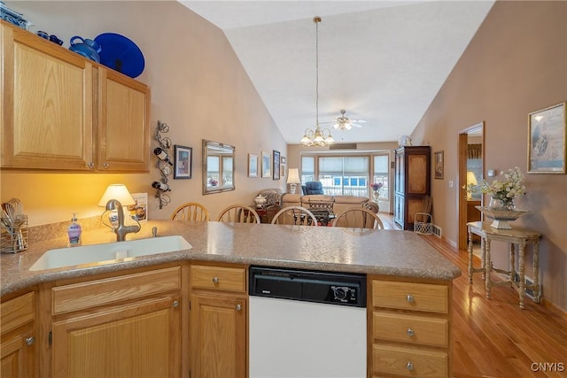 kitchen with white dishwasher, sink, kitchen peninsula, and vaulted ceiling