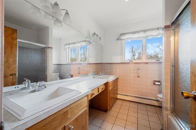 bathroom featuring tile patterned flooring, tile walls, toilet, a baseboard radiator, and vanity