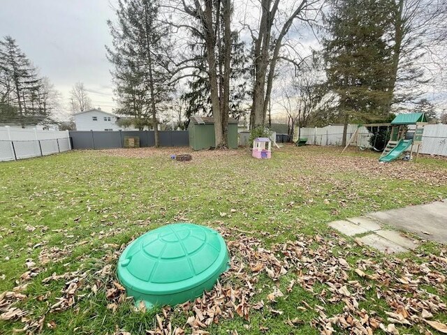 view of yard with a playground and a shed