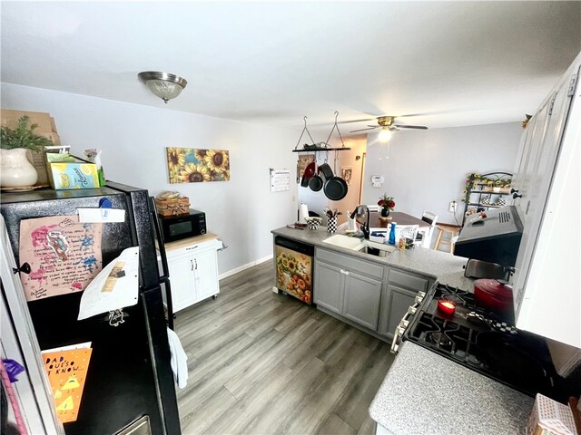 kitchen with sink, white cabinetry, wood-type flooring, black appliances, and gray cabinetry