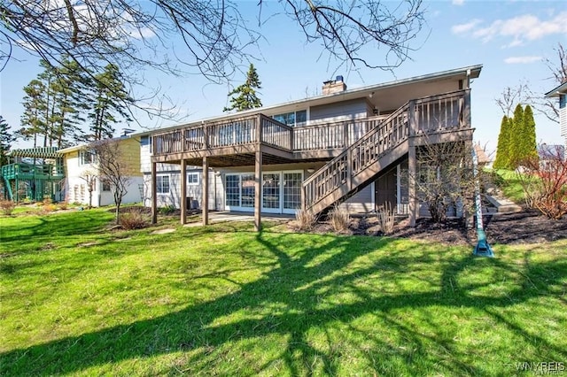 back of property featuring a yard and a wooden deck