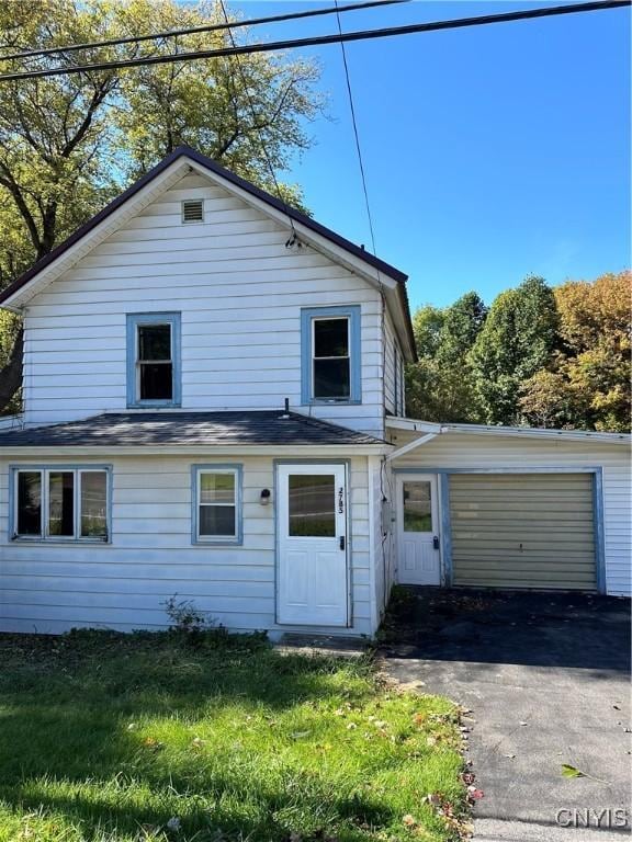 view of property with a front lawn and a garage