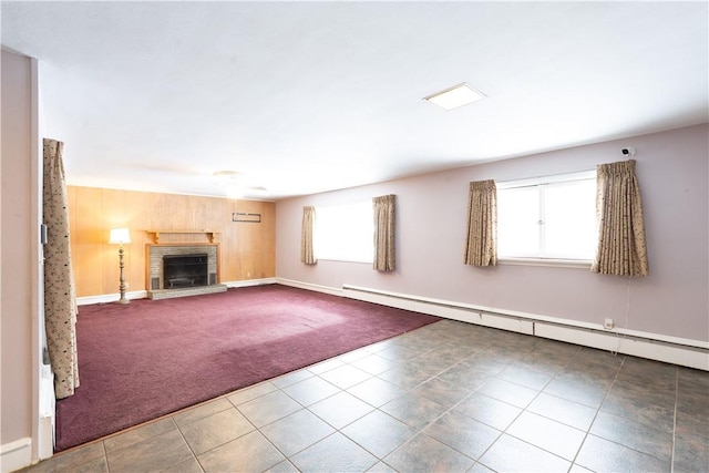 unfurnished living room with a brick fireplace, a baseboard heating unit, and tile patterned floors