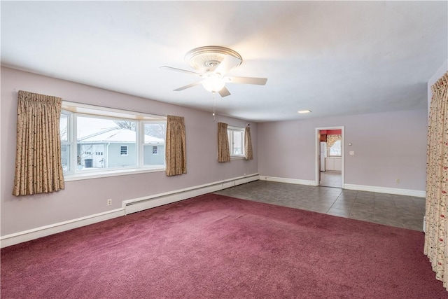 unfurnished room with dark carpet, baseboard heating, and ceiling fan