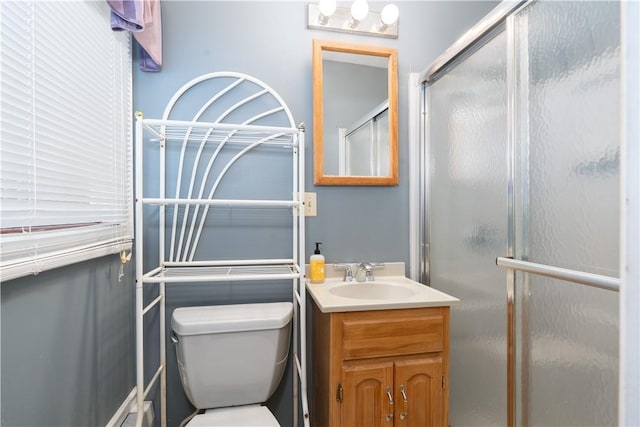 bathroom featuring toilet, vanity, and walk in shower