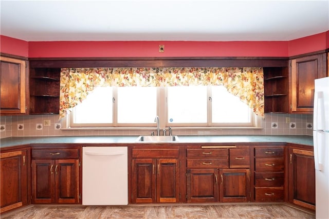 kitchen featuring sink, white appliances, and tasteful backsplash