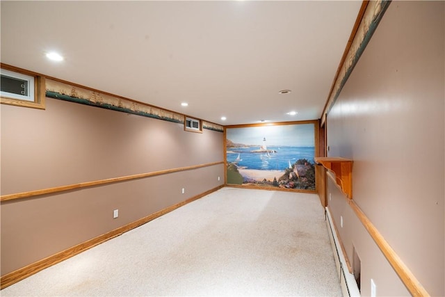 basement with a baseboard heating unit, light colored carpet, and ornamental molding