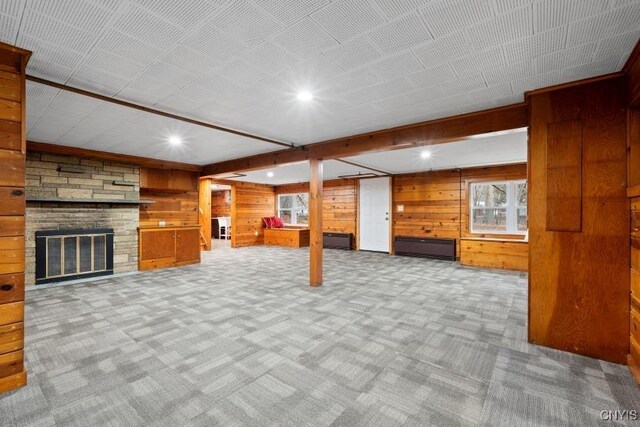 basement with wood walls, a fireplace, and carpet