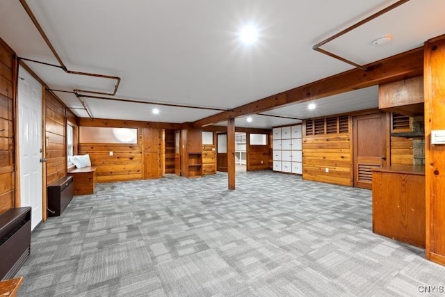 basement with light colored carpet and wood walls