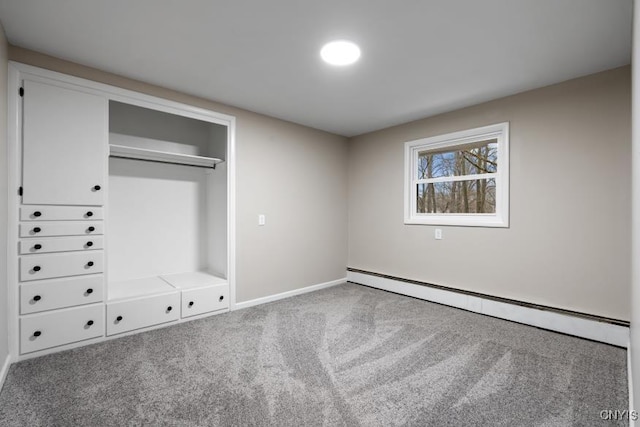 unfurnished bedroom featuring baseboard heating, a closet, and carpet floors